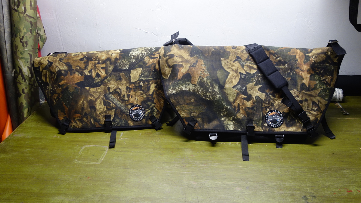 Large and XL realtree slingbags next to each other