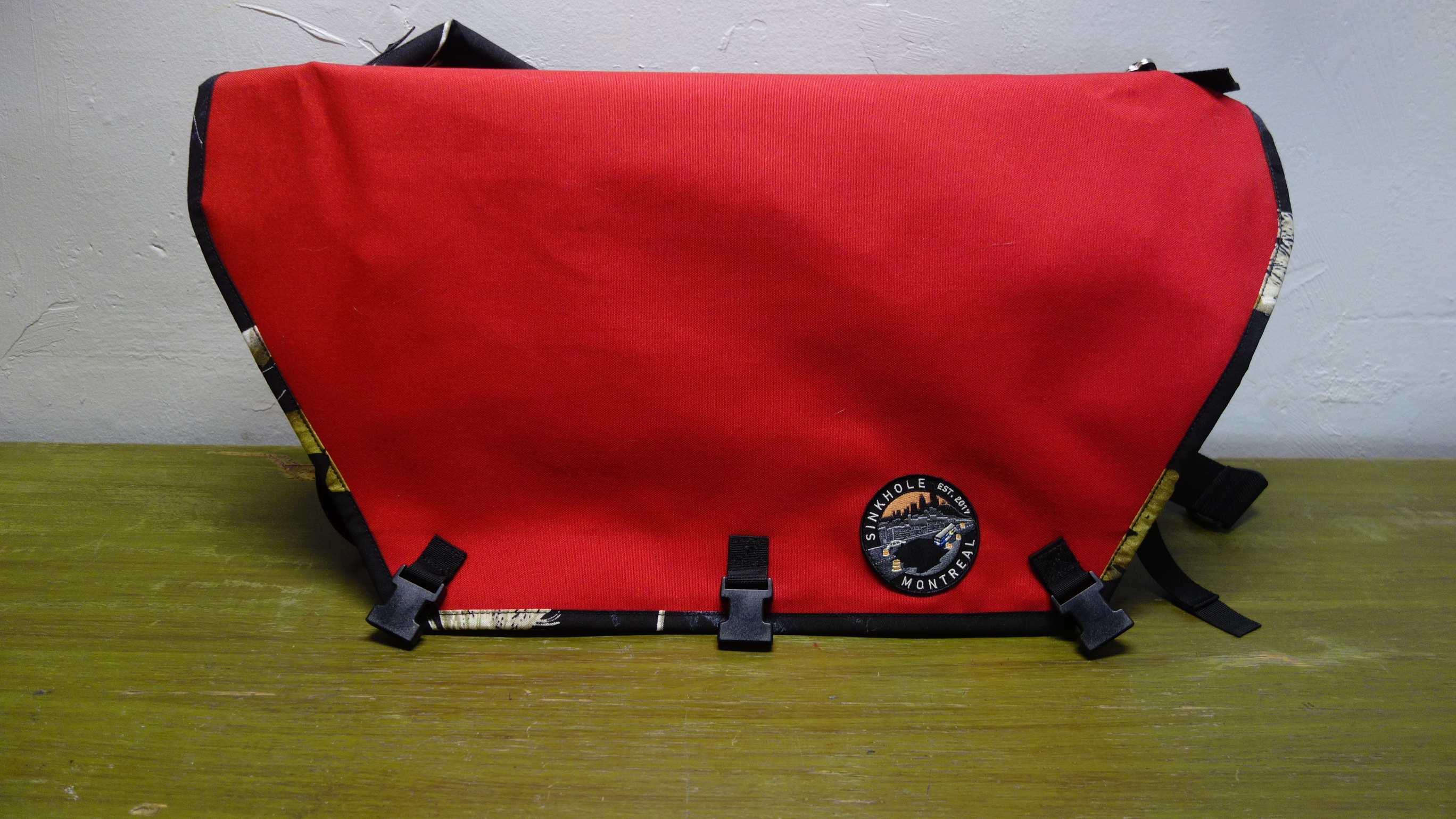 a L sling bag with a black realtree camo trim