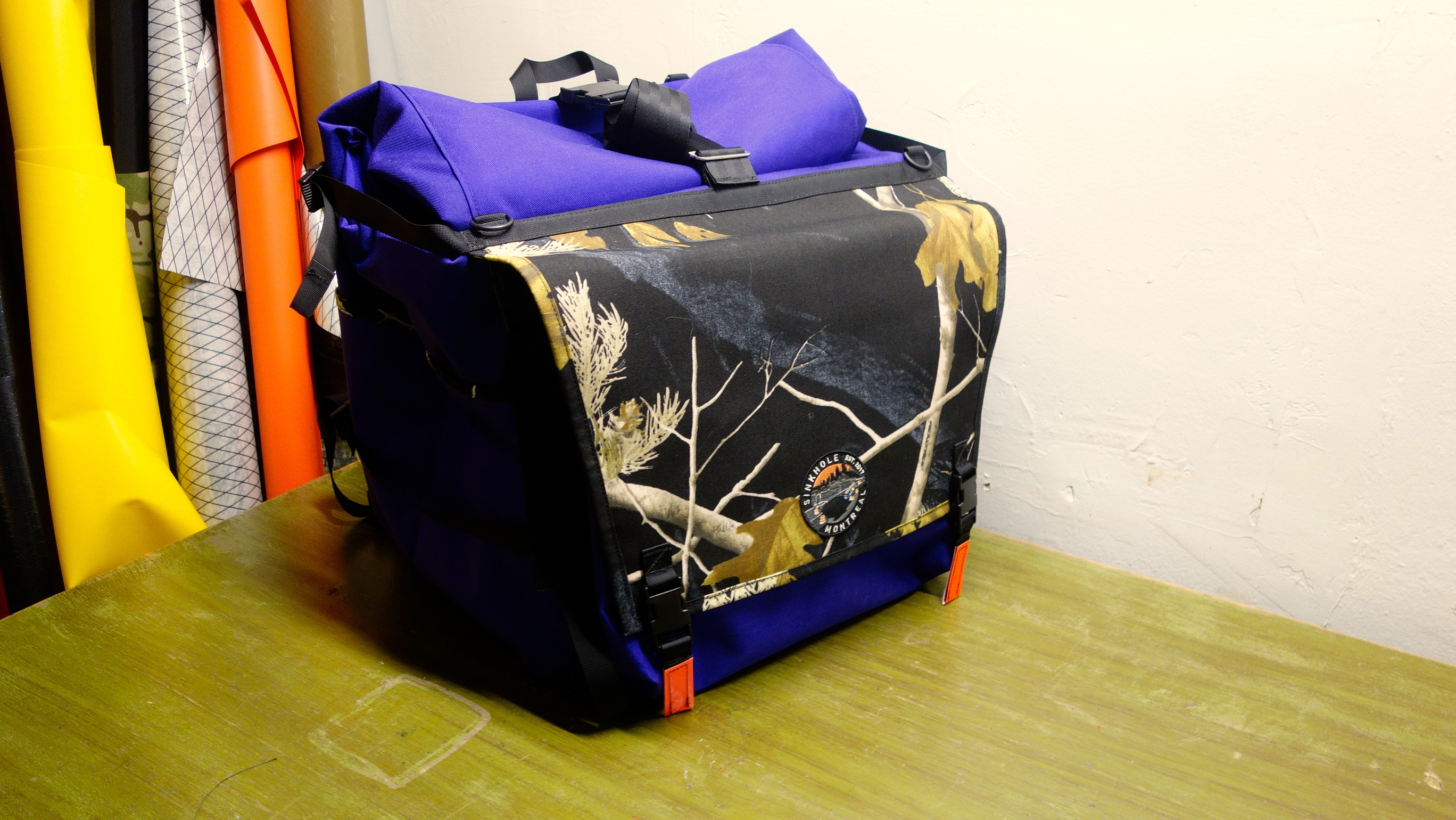 L purple messenger backpak with a black realtree flap